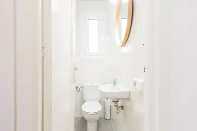 a white bathroom with a toilet and a mirror at Suites4days Sagrada Familia Apartment in Barcelona
