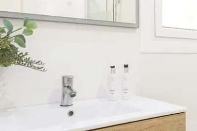 a bathroom sink with two faucets and a mirror at Suites4days Sagrada Familia Apartment in Barcelona