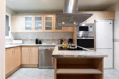 a kitchen with wooden cabinets and stainless steel appliances at AB Princep Jordi in Barcelona