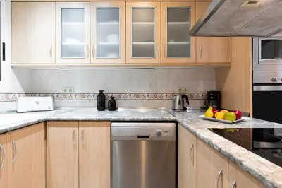 a kitchen with wooden cabinets and a dishwasher at AB Princep Jordi in Barcelona