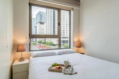 a bed with a tray of food on it with a window at 4168 - AB Josep Pla- Diagonal Mar in Barcelona