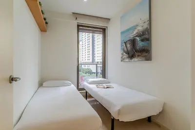 two beds in a room with a window at 4168 - AB Josep Pla- Diagonal Mar in Barcelona