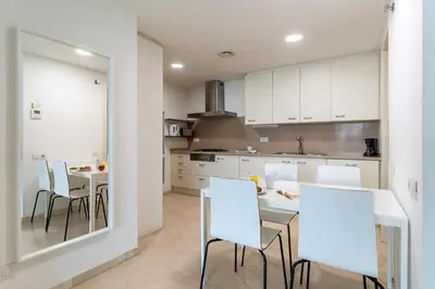 a kitchen with white cabinets and a table and chairs at 4168 - AB Josep Pla- Diagonal Mar in Barcelona