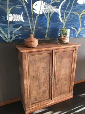 a wooden cabinet with a painting on the wall at Sea Views Penthouse in Sitges