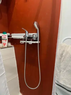 a shower with a hose attached to a wall at Tessasapartments Sabadell 4 in Sabadell