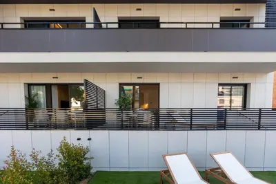 a house with a balcony with chairs on it at Fels Apartments in Castelldefels