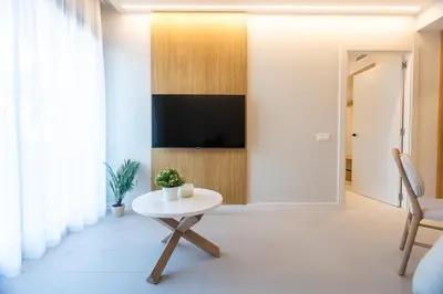 a living room with a table and a tv at Fels Apartments in Castelldefels