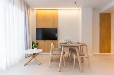 a dining room with a table and a tv at Fels Apartments in Castelldefels