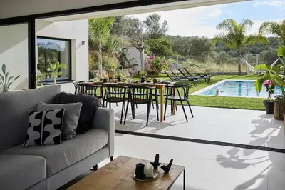a living room with a couch and a table at Villa Sitges Casa Selva 7 minutos de Sitges en coche Diseño Comodidad Nueva Ideal para Vacaciones in Sant Pere de Ribes