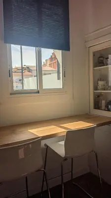 a table and two chairs in a room with a window at Centric apartment 100m from the beach in Mataró