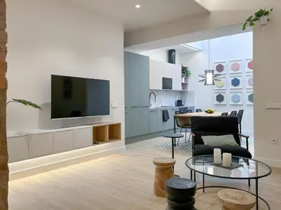 a living room with a television and a table at Apartment Gaudi in Vilanova i la Geltrú