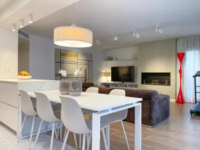 a kitchen and living room with a white table and chairs at Apartment Monet in Vilanova i la Geltrú