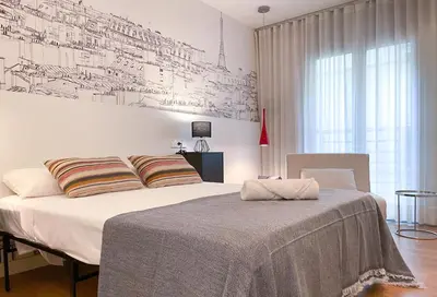 a bedroom with a bed and a wall with drawings on it at Apartment Monet in Vilanova i la Geltrú