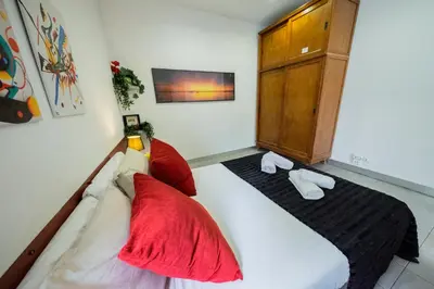 a bedroom with a bed with red pillows and a cabinet at rentBCN Paseo de Gracia Apartments in Barcelona