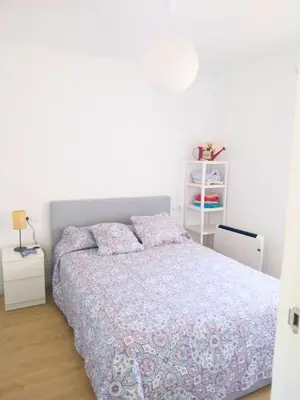 a white bedroom with a bed and a white shelf at Apartment by the sea in Cubelles in Cubelles