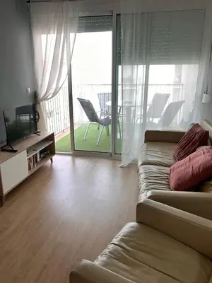 a living room with a couch and a television at Apartment by the sea in Cubelles in Cubelles