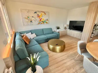 a living room with a blue couch and a table at Atico Barcelona Playa in Sant Adria de Besos