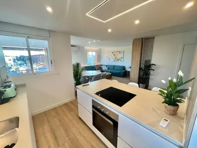 a kitchen and living room with a couch and a table at Atico Barcelona Playa in Sant Adria de Besos