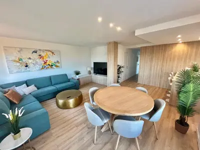 a living room with a blue couch and a table at Atico Barcelona Playa in Sant Adria de Besos
