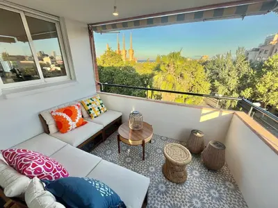 a balcony with a couch and a table and a window at Atico Barcelona Playa in Sant Adria de Besos