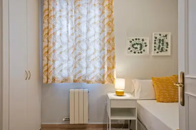 a bedroom with a bed and a table with a lamp at Alcam Mallorca 22 in Barcelona
