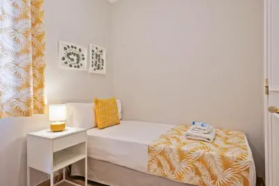 a small bedroom with a bed and a night stand at Alcam Mallorca 22 in Barcelona
