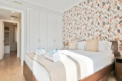 a bedroom with a large bed with two towels on it at Alcam Mallorca 22 in Barcelona