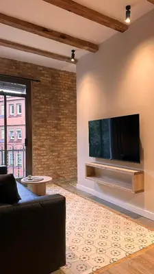 a living room with a flat screen tv on a wall at La Fira - Paralelo 2 in Barcelona