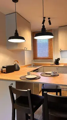 a kitchen with two lights and a table with chairs at La Fira - Paralelo 2 in Barcelona