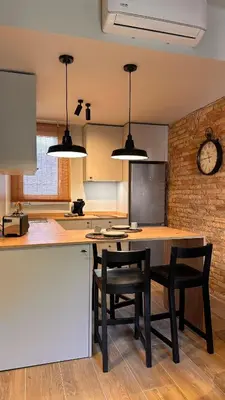 a kitchen with a table and chairs and a clock at La Fira - Paralelo 2 in Barcelona
