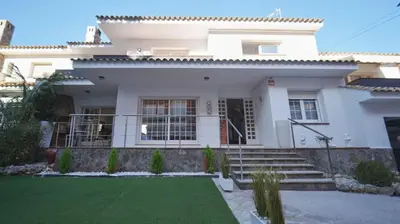a white house with a lawn in front of it at SeaHomes Vacations - Villa Chill & Pool 200m Beach in Pineda de Mar
