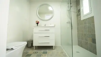 a white bathroom with a sink and a mirror at SeaHomes Vacations - Villa Chill & Pool 200m Beach in Pineda de Mar