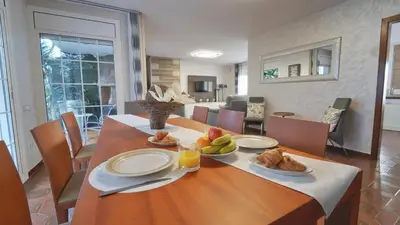 a dining room table with plates of food on it at SeaHomes Vacations - Villa Chill & Pool 200m Beach in Pineda de Mar