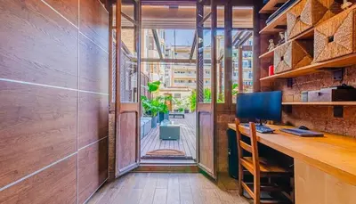 an office with a desk with a computer and a window at Unique central home with large terrace & pool in Barcelona