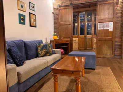 a living room with a couch and a tv at Unique central home with large terrace & pool in Barcelona
