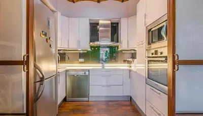 a kitchen and dining room with a wooden table at Unique central home with large terrace & pool in Barcelona