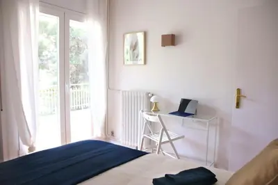a bedroom with a bed and a desk and a window at Apartamentos Villa Valle in Castelldefels
