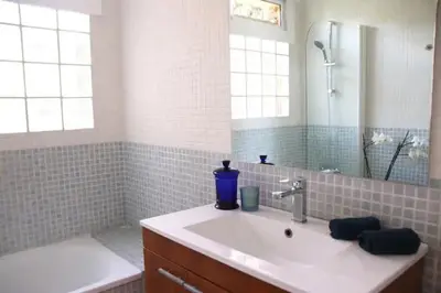 a bathroom with a sink and a mirror and a tub at Apartamentos Villa Valle in Castelldefels