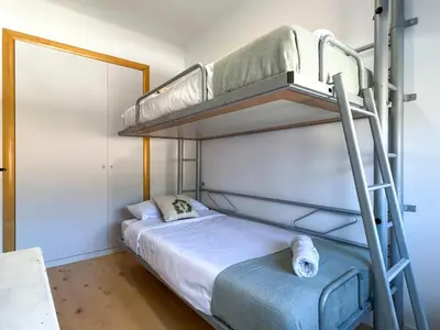 a bedroom with a large bed with white sheets at PalmBreeze in Vilanova i la Geltrú