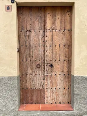 an old wooden door on a building at Old Town Montserrat in Collbató
