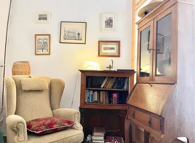 a living room with a chair and a book shelf at Old Town Montserrat in Collbató