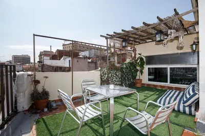 a patio with a table and chairs on a balcony at luminous top floor apartment with terrace in Barcelona