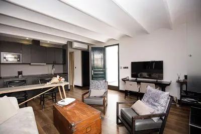 a kitchen and living room with a table and chairs at luminous top floor apartment with terrace in Barcelona