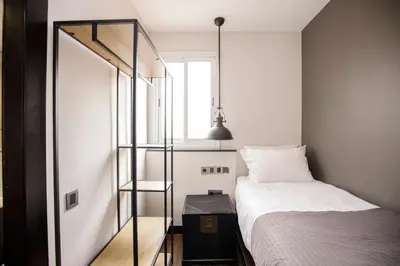 a small bedroom with a bed and a window at luminous top floor apartment with terrace in Barcelona