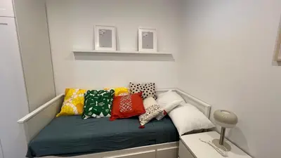 a bed with colorful pillows on it in a room at Piso Centro Badalona in Badalona