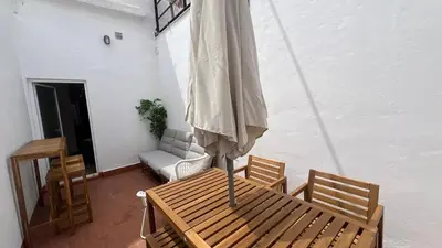 a table and chairs with an umbrella in a room at Piso Centro Badalona in Badalona