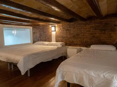 two beds in a room with a brick wall at Casa Gracia con Jardín in Barcelona