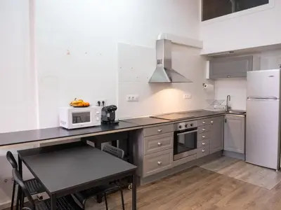 a kitchen with a counter with a microwave and a refrigerator at Casa Gracia con Jardín in Barcelona