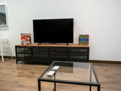 a flat screen tv sitting on top of a entertainment center at Casa Gracia con Jardín in Barcelona