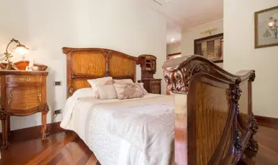 a bedroom with a large wooden bed with white sheets at Hotel Boutique Edelweiss La Garriga in La Garriga